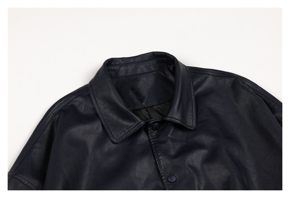 Close-up of the black jacket's pointed collar, shoulder seams and upper snap-button placket.