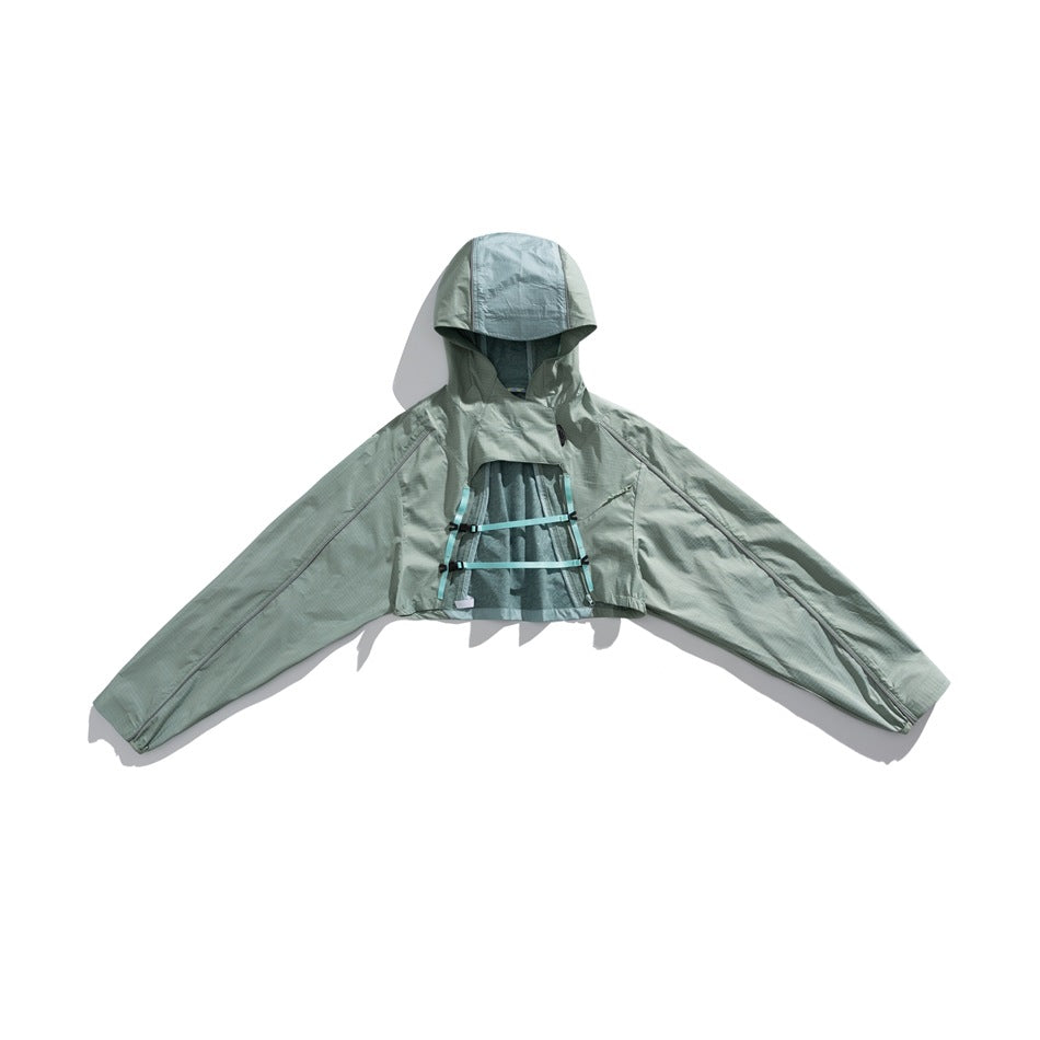 Front view of a pale sage cropped hooded jacket with wide sleeves and horizontal chest straps.