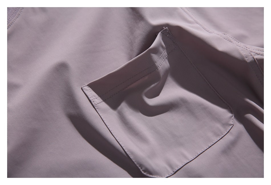 Close-up of a stitched patch pocket on a muted mauve garment.