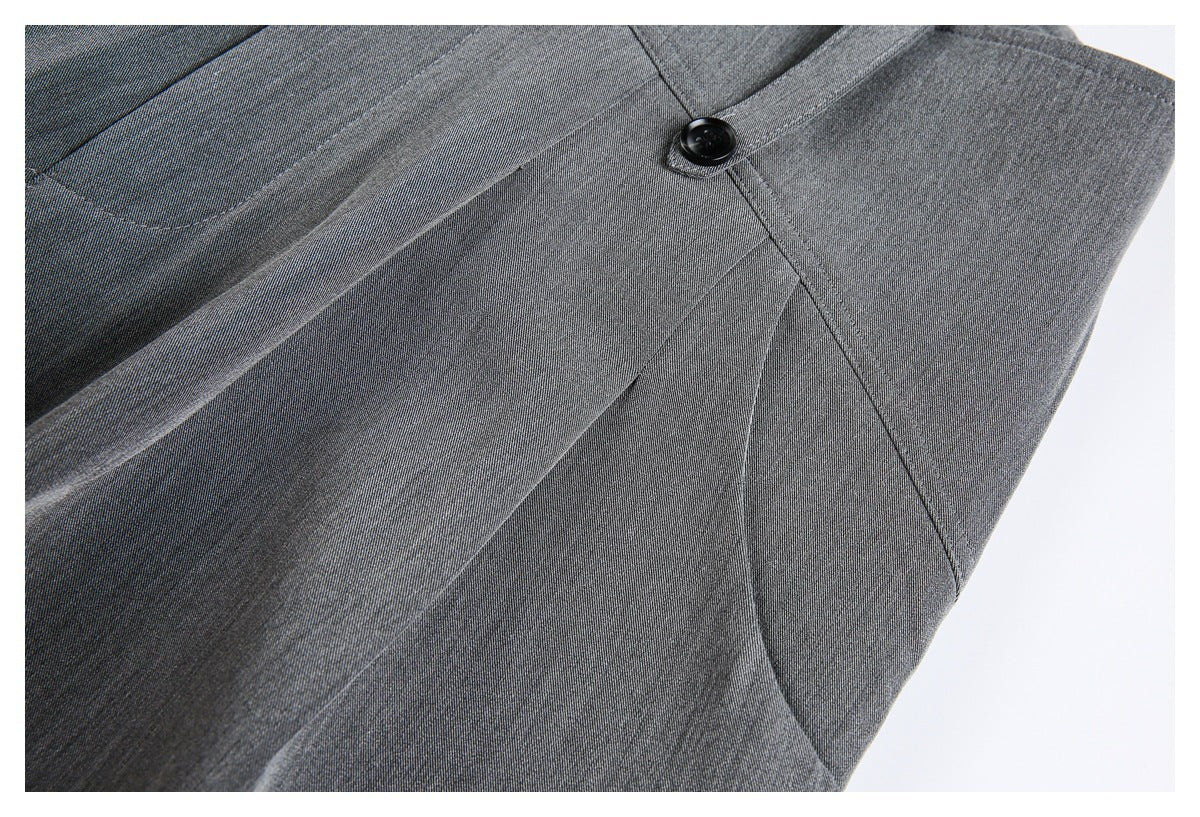 Close-up of gray trouser fabric, stitching, and a black button at a seam.