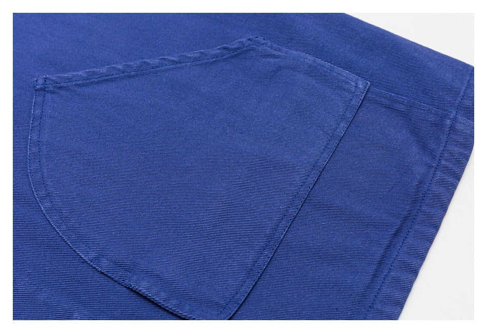 Close-up of a curved patch pocket stitched onto blue fabric.