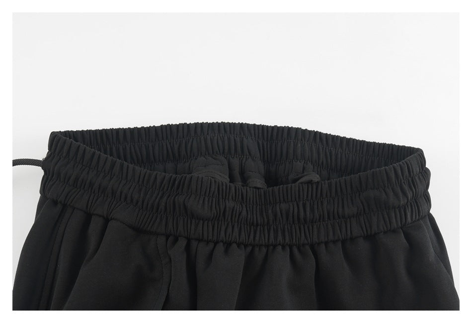 Close-up of the black pants' gathered elastic waistband viewed from above.