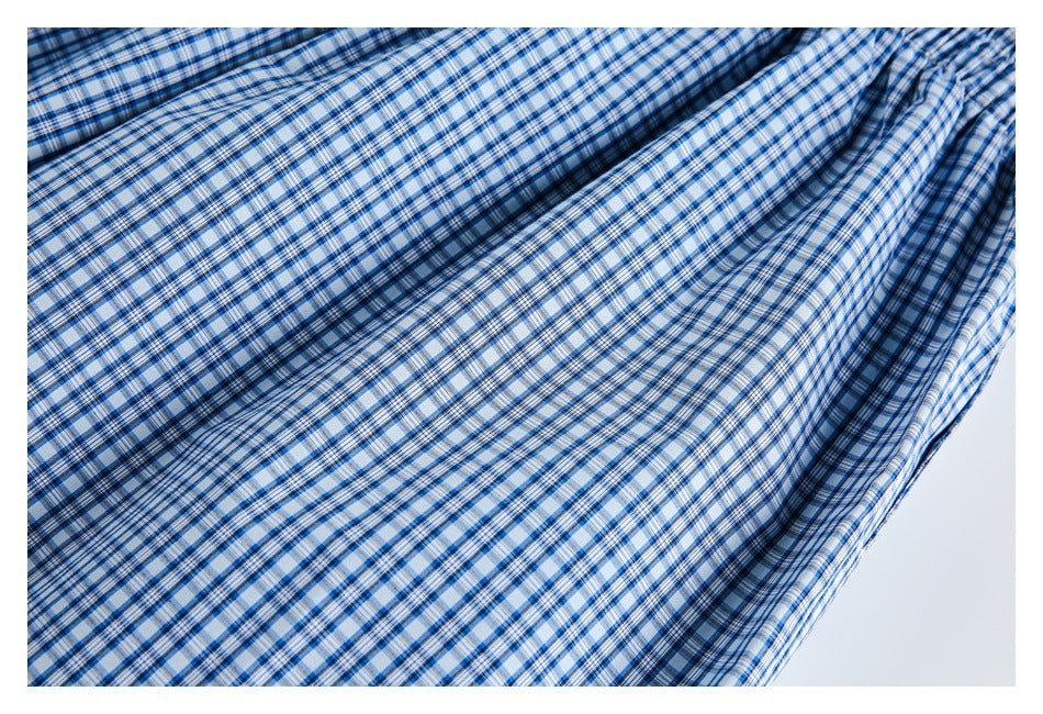 Close-up of blue-and-white plaid fabric draped into soft folds.