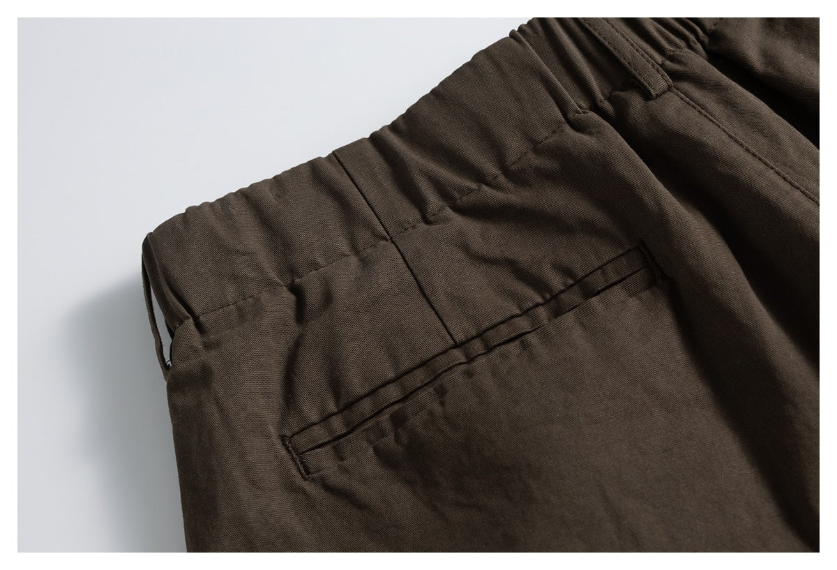 Close-up of a dark brown trouser back welt pocket and gathered waistband.