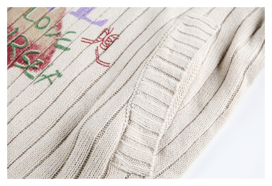 Close-up of the cream rib-knit garment's ribbed edge beside part of its colorful graphic.