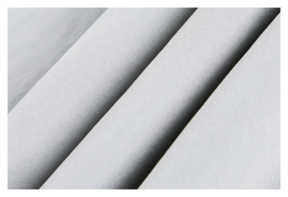 Macro view of pale gray fabric folds showing its fine surface texture.