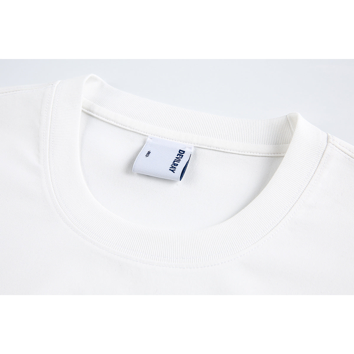 Close-up of a white T-shirt’s ribbed crew neck and sewn-in label.