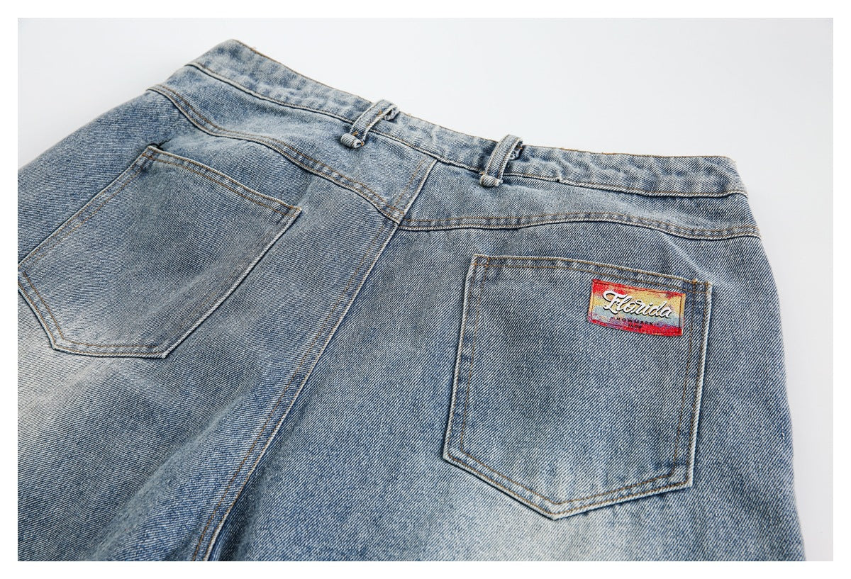 Rear view of washed blue jeans with two back pockets and a small Florida patch on one pocket.