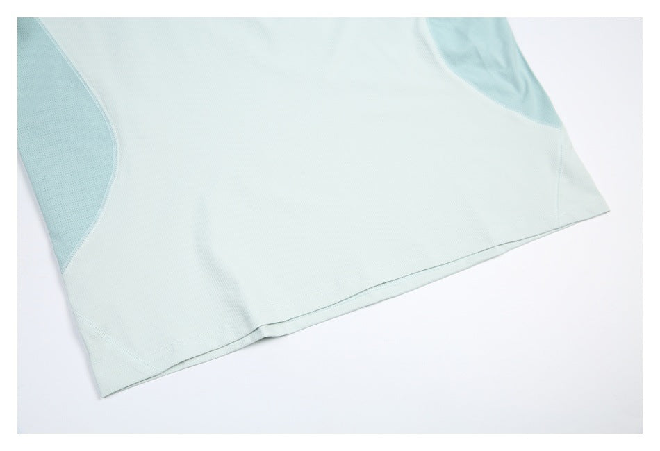Close-up of the pale mint shirt's lower hem and curved, perforated side panels.