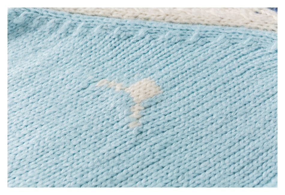 Close-up of aqua knit fabric showing the pale reverse side of an embroidered motif.