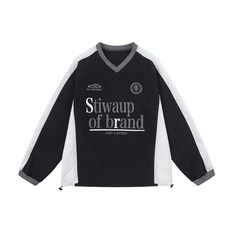 Front of a black and off-white color-blocked long-sleeve V-neck top with gray trim and printed chest lettering and emblems.