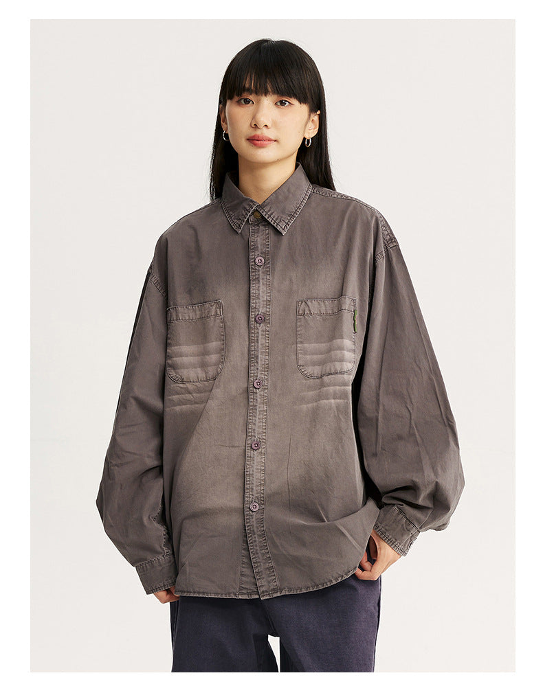 Front view of a model wearing an oversized smoky gray button-up shirt with two chest pockets.