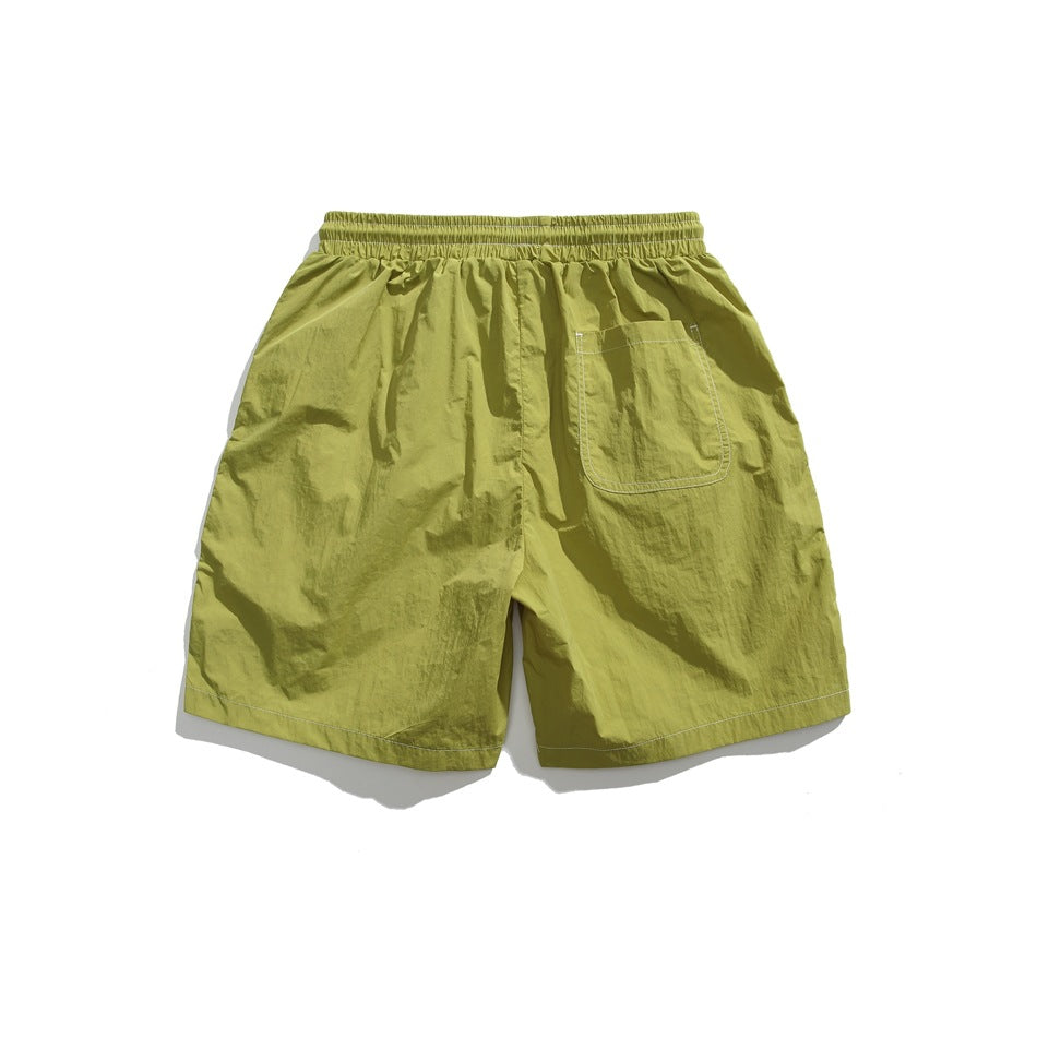 Back view of lime-green shorts with an elastic waistband and a single rear pocket.