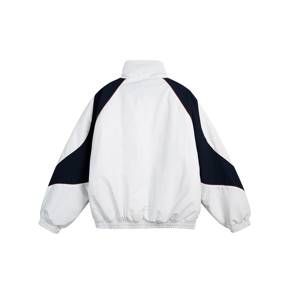 Back view of a white high-collar jacket with navy shoulder and sleeve panels, thin burgundy piping and elastic cuffs and hem.