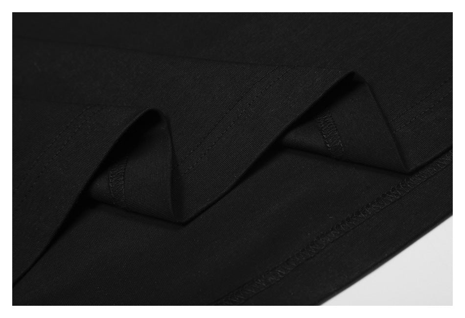 Close-up of folded black fabric showing hem stitching and the garment's inner seam.