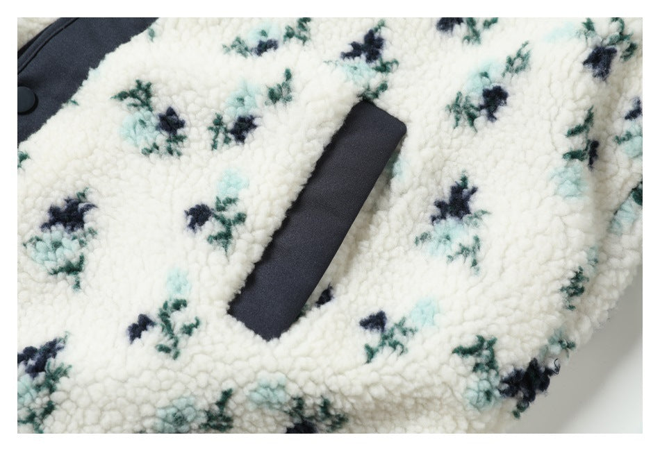 Close-up of a dark-trimmed pocket opening on the cream floral sherpa jacket.