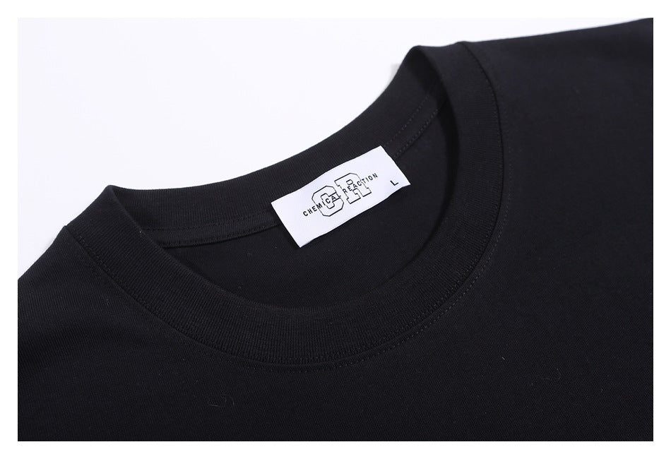 Close-up of the black T-shirt’s ribbed crew neck and white size label.