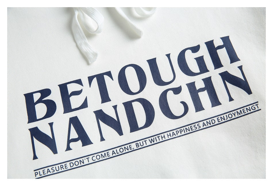 Close-up of a white hoodie with navy lettering and a small slogan printed across the chest, with white drawstrings above.