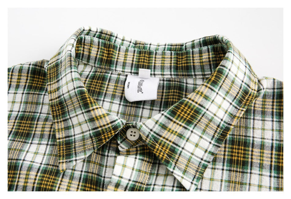 Close-up of the plaid shirt's pointed collar, top button, and sewn-in neck label.