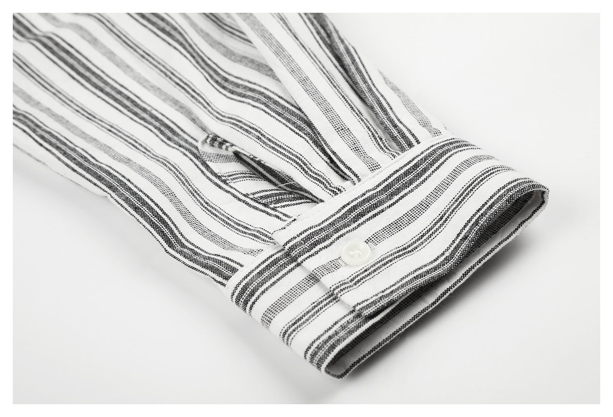 Close-up of a white buttoned cuff with black and gray stripes on a matching sleeve.