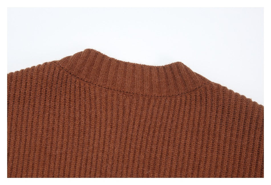 Close-up of the ribbed neckline and shoulder area of a rust-brown knit sweater.