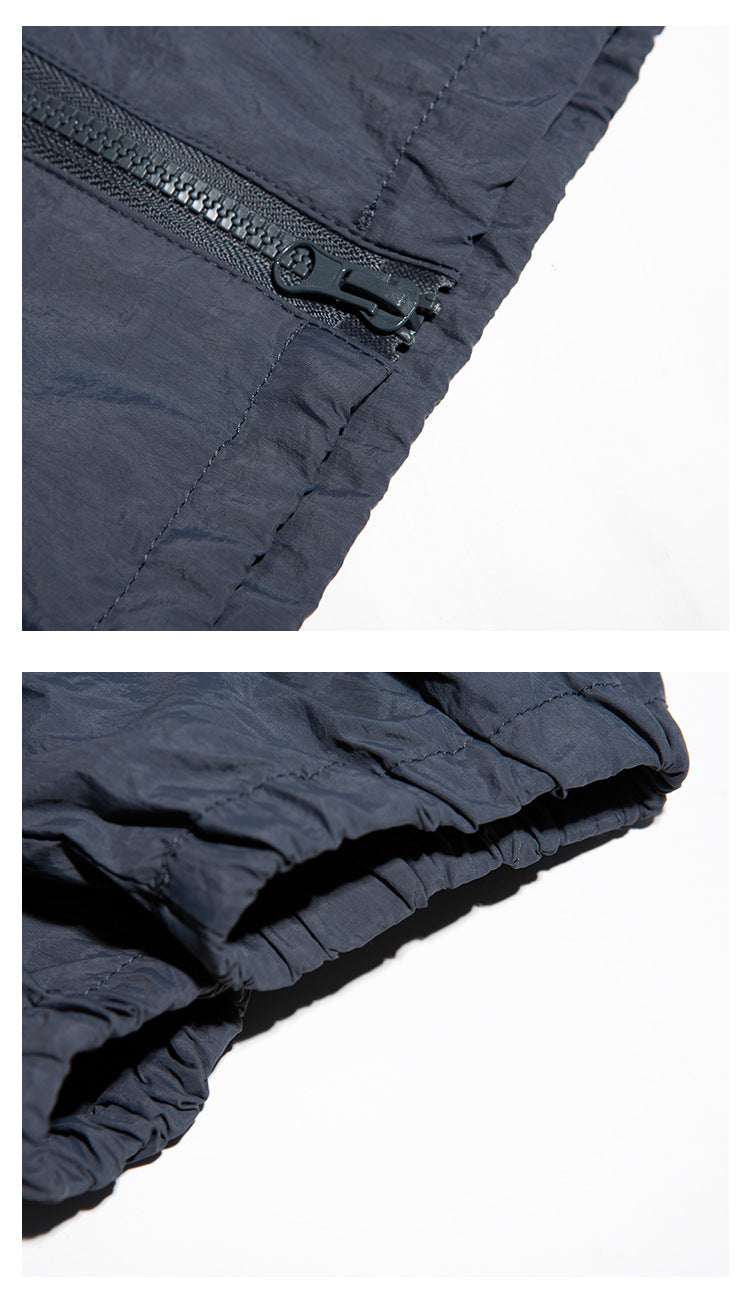 Close-ups of the navy jacket's zipper pull and gathered elastic cuff.