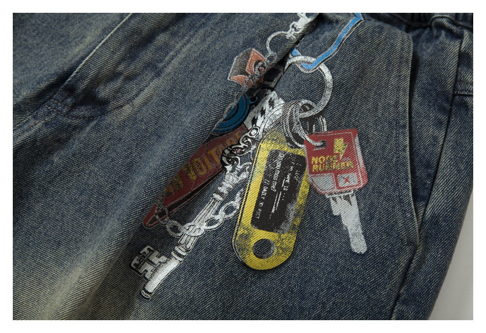 Close-up of faded blue denim with colorful key and chain graphics printed on the fabric.