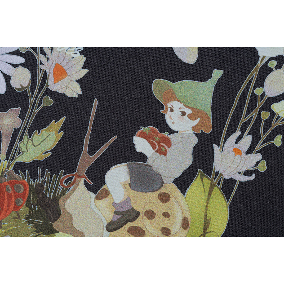 Close-up of a colorful garden illustration printed on charcoal fabric, with flowers, insects, and a small character.