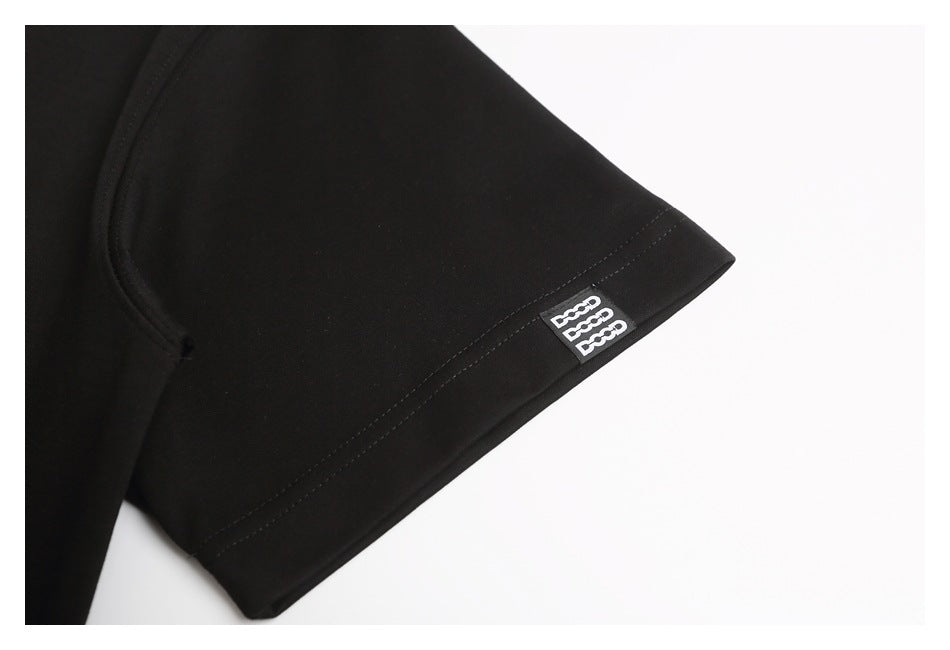 Close-up of a black T-shirt sleeve hem with a small white logo tab.