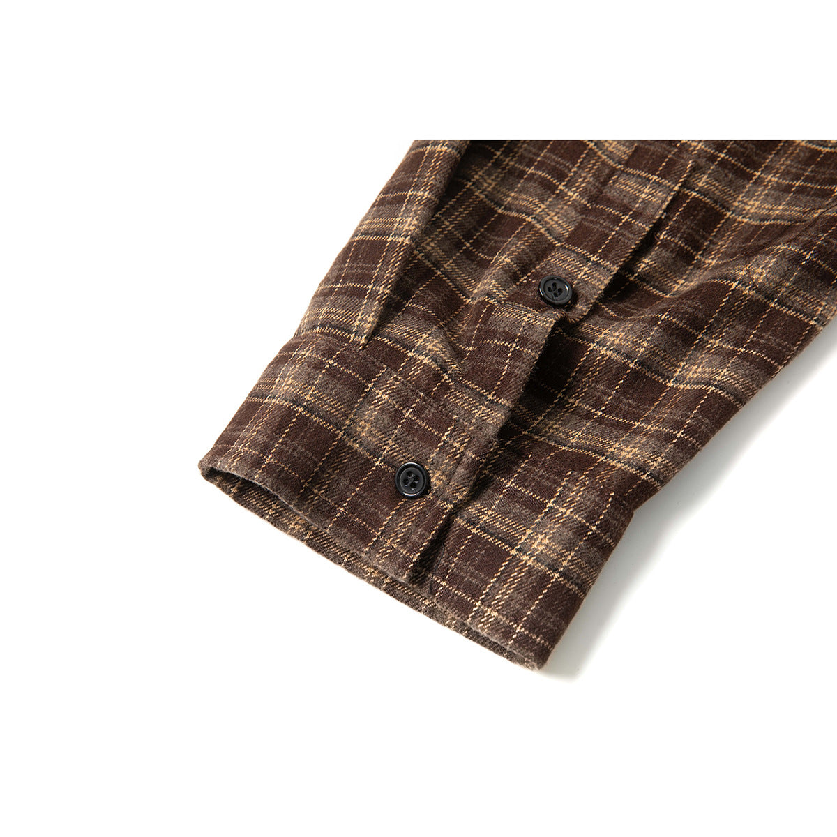 Close-up of a brown plaid shirt sleeve cuff with two black buttons.