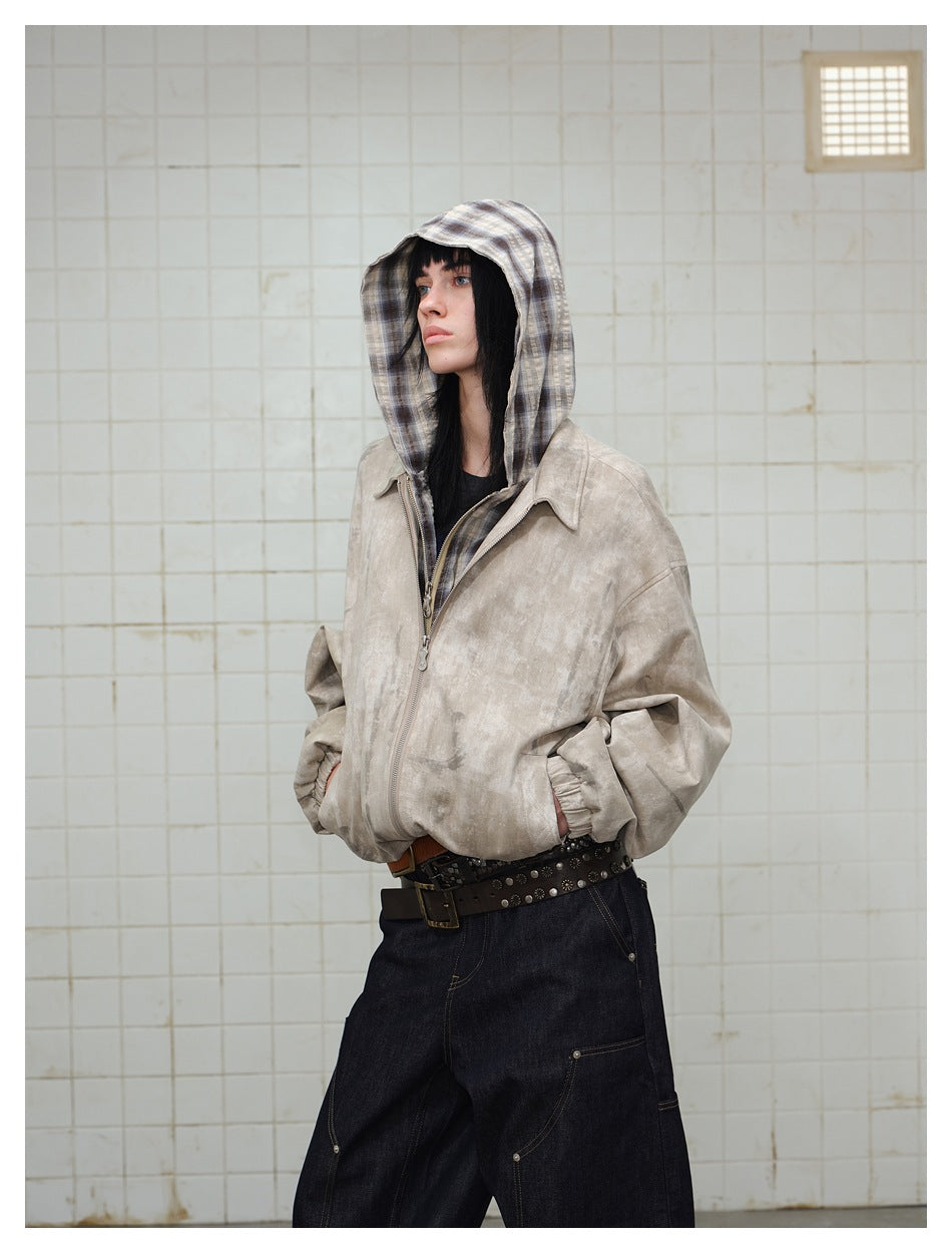 Side view of model in khaki distressed jacket with plaid hood up, showing loose sleeves and elastic cuffs