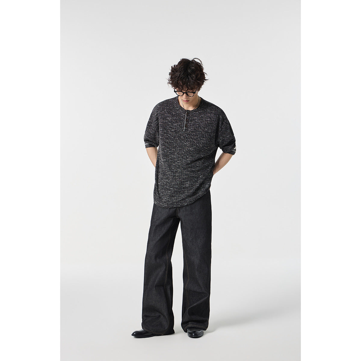 Model wearing a charcoal heathered short-sleeve henley with dark wide-leg jeans.
