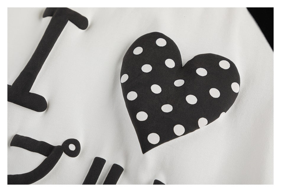 Close-up of the shirt's black heart graphic filled with white dots and surrounding lettering.