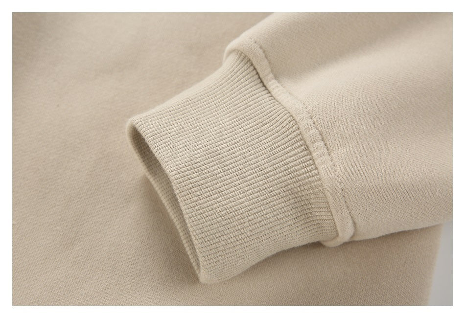 Close-up of a beige sweatshirt sleeve ending in a wide ribbed cuff.