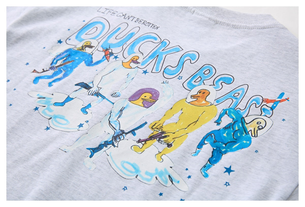 Colorful graphic on a light gray T-shirt shows cartoon figures, stars, and large blue lettering.