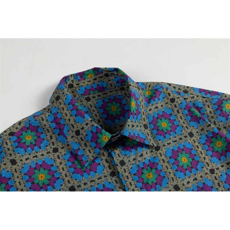 Close-up of the collar and shoulder of a gray short-sleeve shirt with vivid blue, purple, and teal floral motifs.