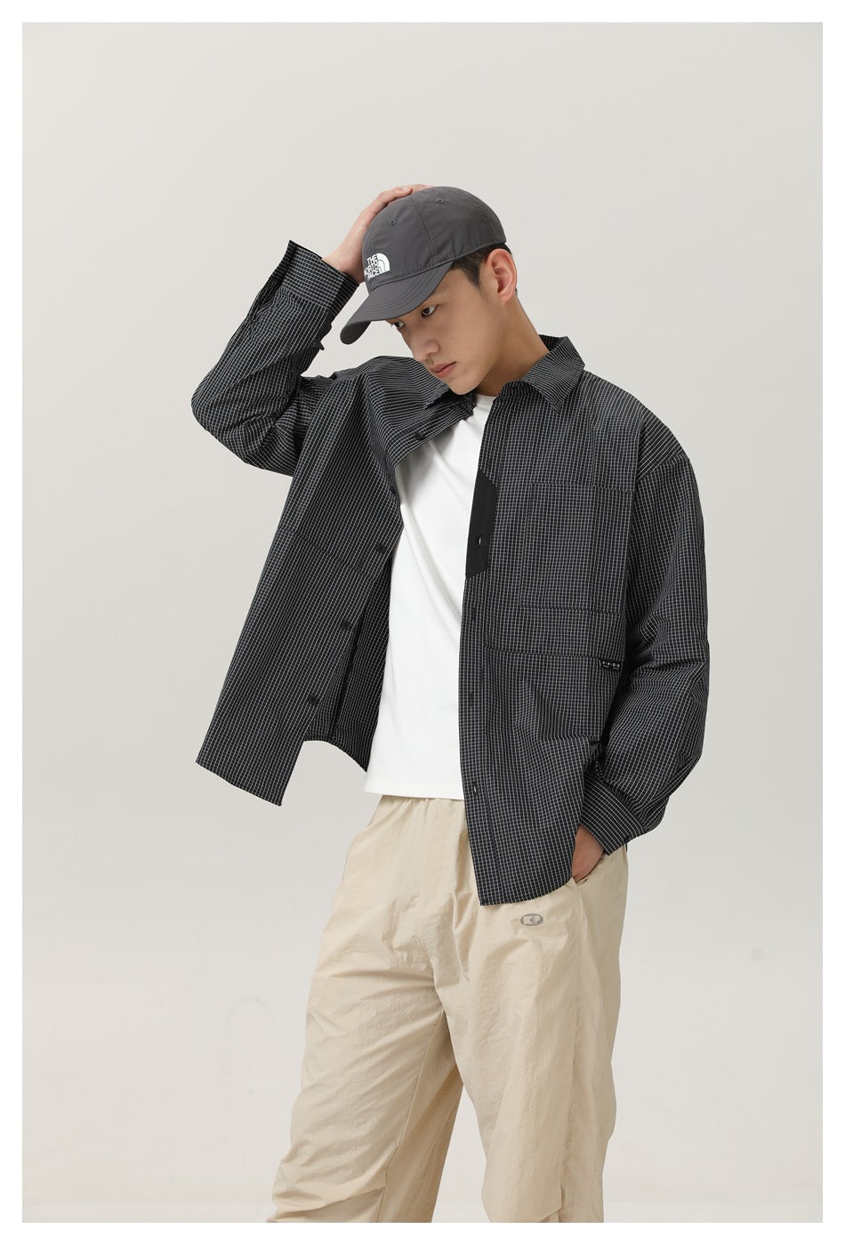 Model in an open charcoal micro-check shirt over a white tee, framed from head to upper legs.