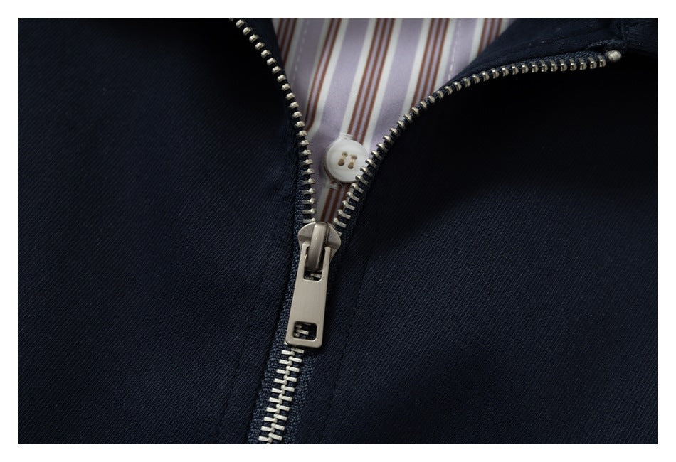 Close-up of the jacket's silver front zipper, with a white button and striped lining visible beneath it.