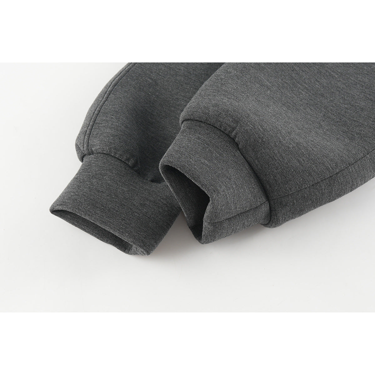 Close-up of the charcoal gray jacket's ribbed cuffs and sleeve seams.
