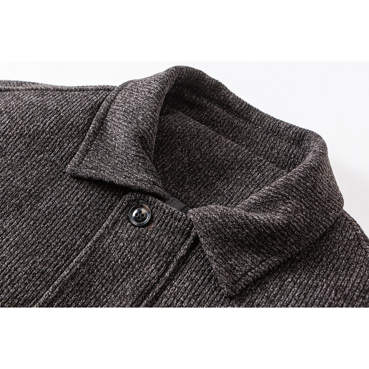 Close-up of a charcoal textured jacket collar and a black button.
