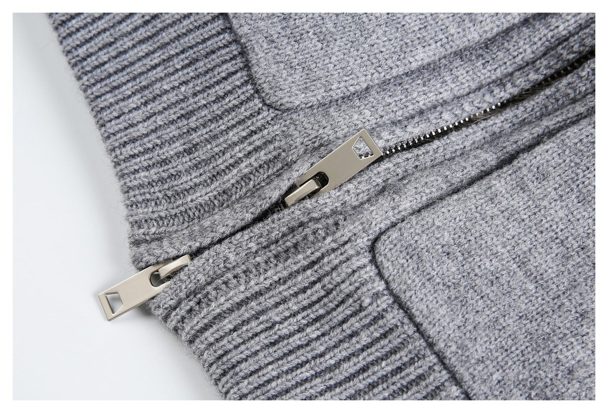 Close-up of a gray knit garment with ribbed trim and a metal zipper.