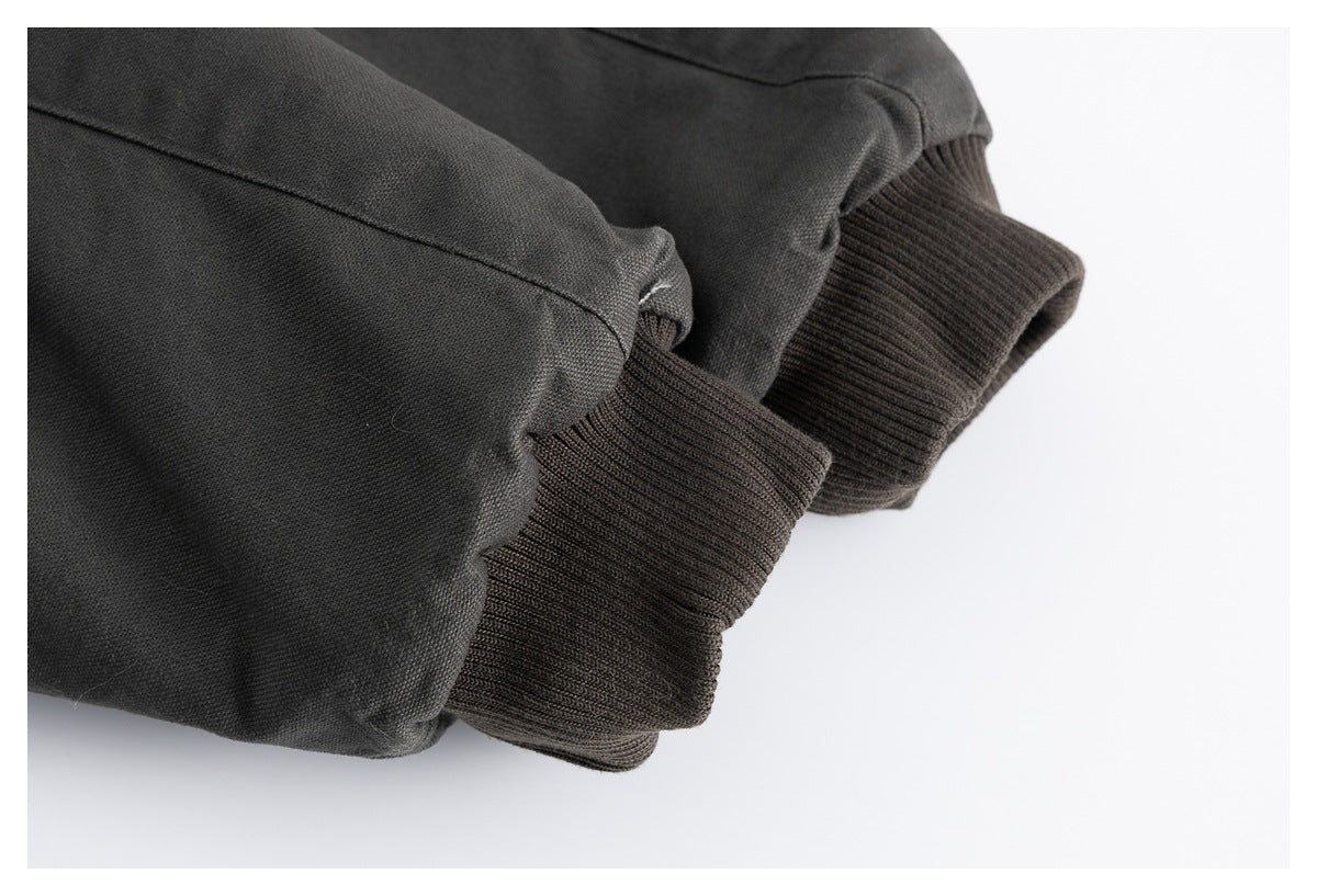 Close-up of dark jacket sleeves finished with wide ribbed cuffs.