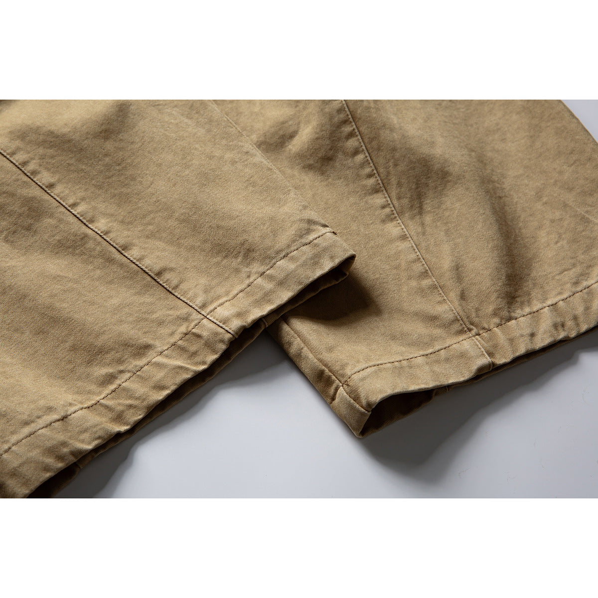 Close-up of tan trouser legs showing seams and finished hems.