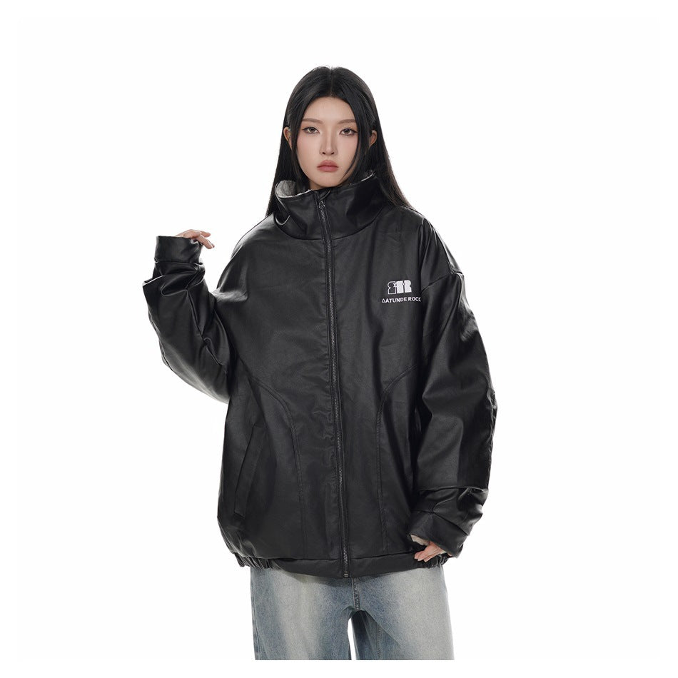 Model wearing an oversized black zip-front jacket with a tall collar and curved front pockets.