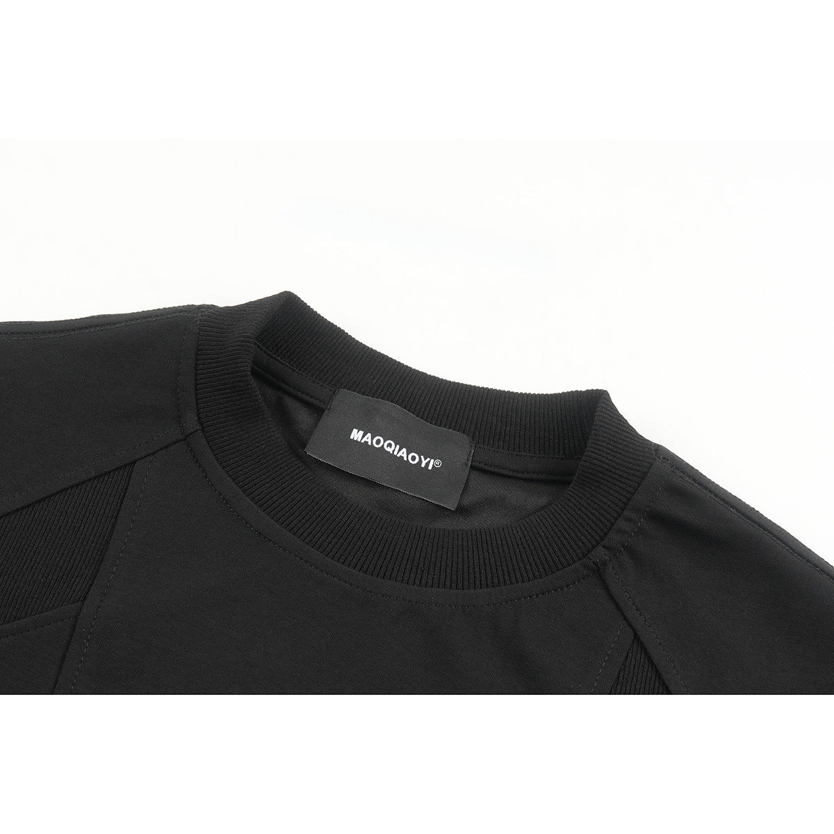 Close-up of a black crew-neck T-shirt showing its ribbed collar, seams, and sewn neck label.