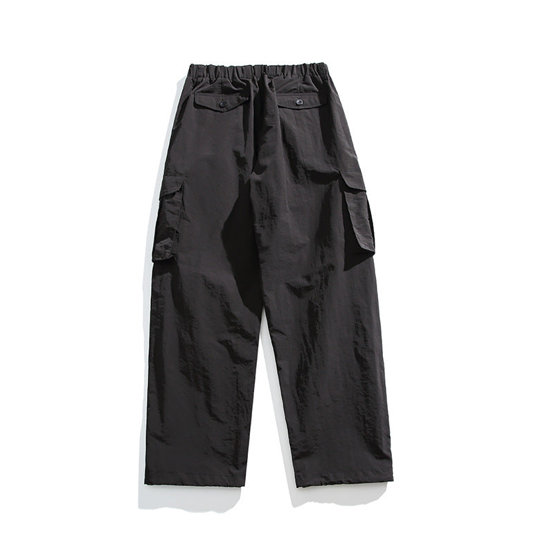 Black wide-leg cargo pants flat lay, back view, with elastic waist, button-flap back pockets and side cargo pockets