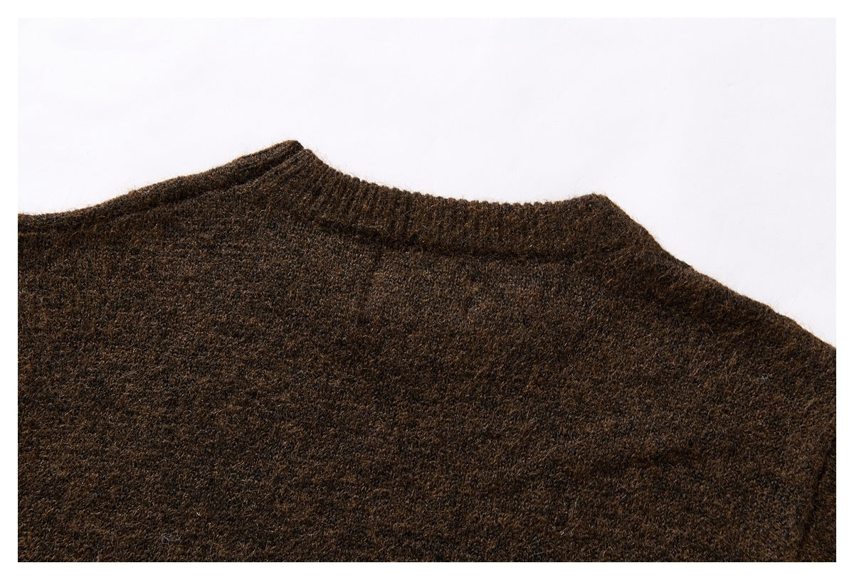 Close-up of a dark brown sweater's ribbed neckline and shoulder.