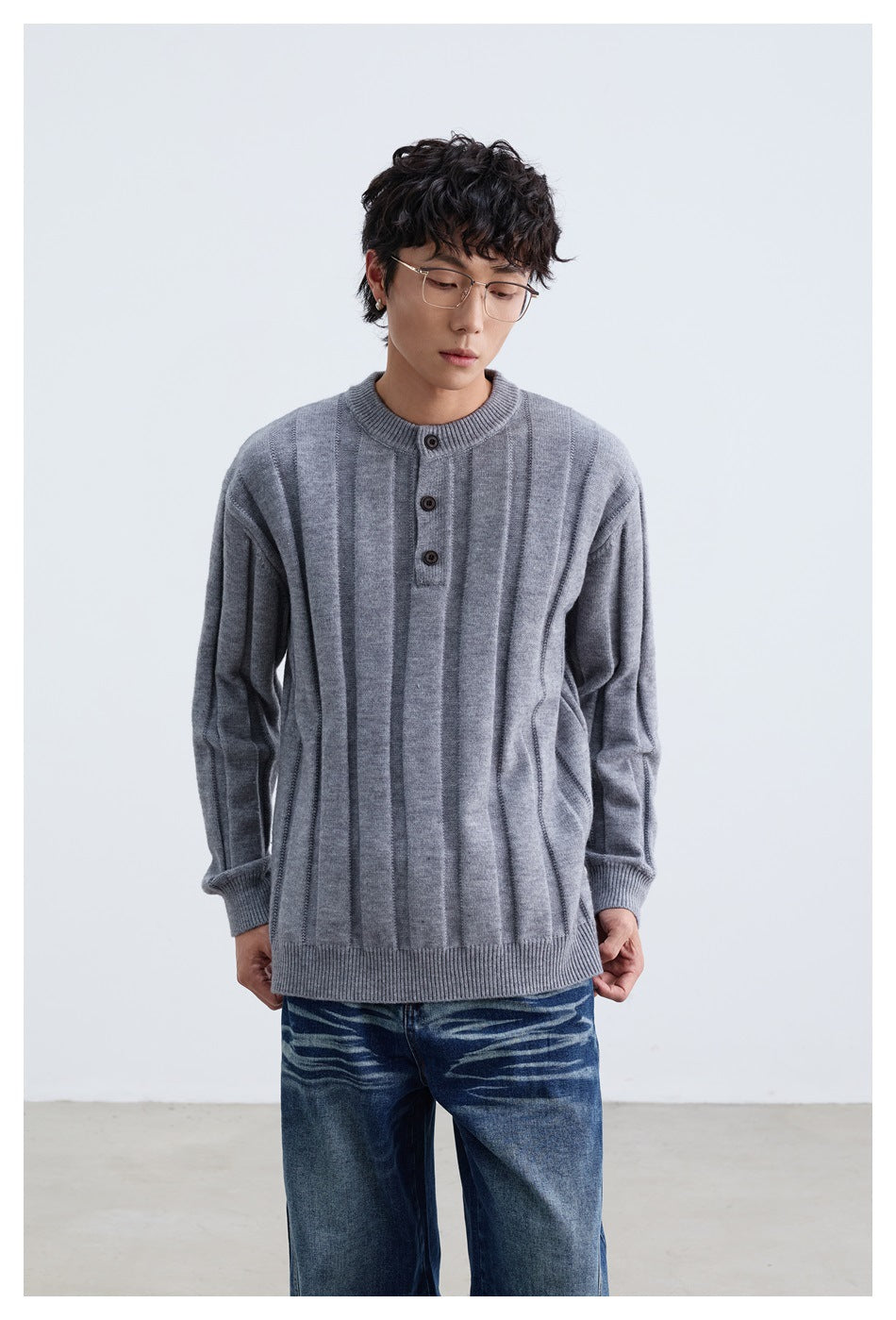 Model wearing a gray sweater with vertical panels, ribbed cuffs and hem, and a three-button neck.