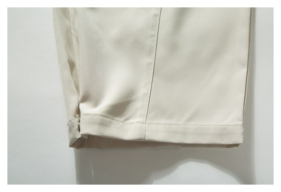 Close-up of the ivory pants leg hem, stitching, and side snap.