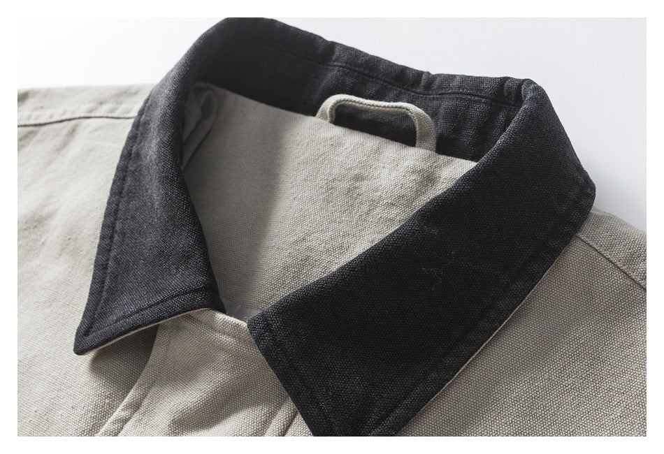 Close-up of a beige jacket's wide dark charcoal collar and light inner neck loop.